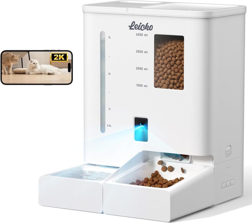 Sleek white automatic pet feeder with camera and transparent kibble window, next to a smart water fountain.